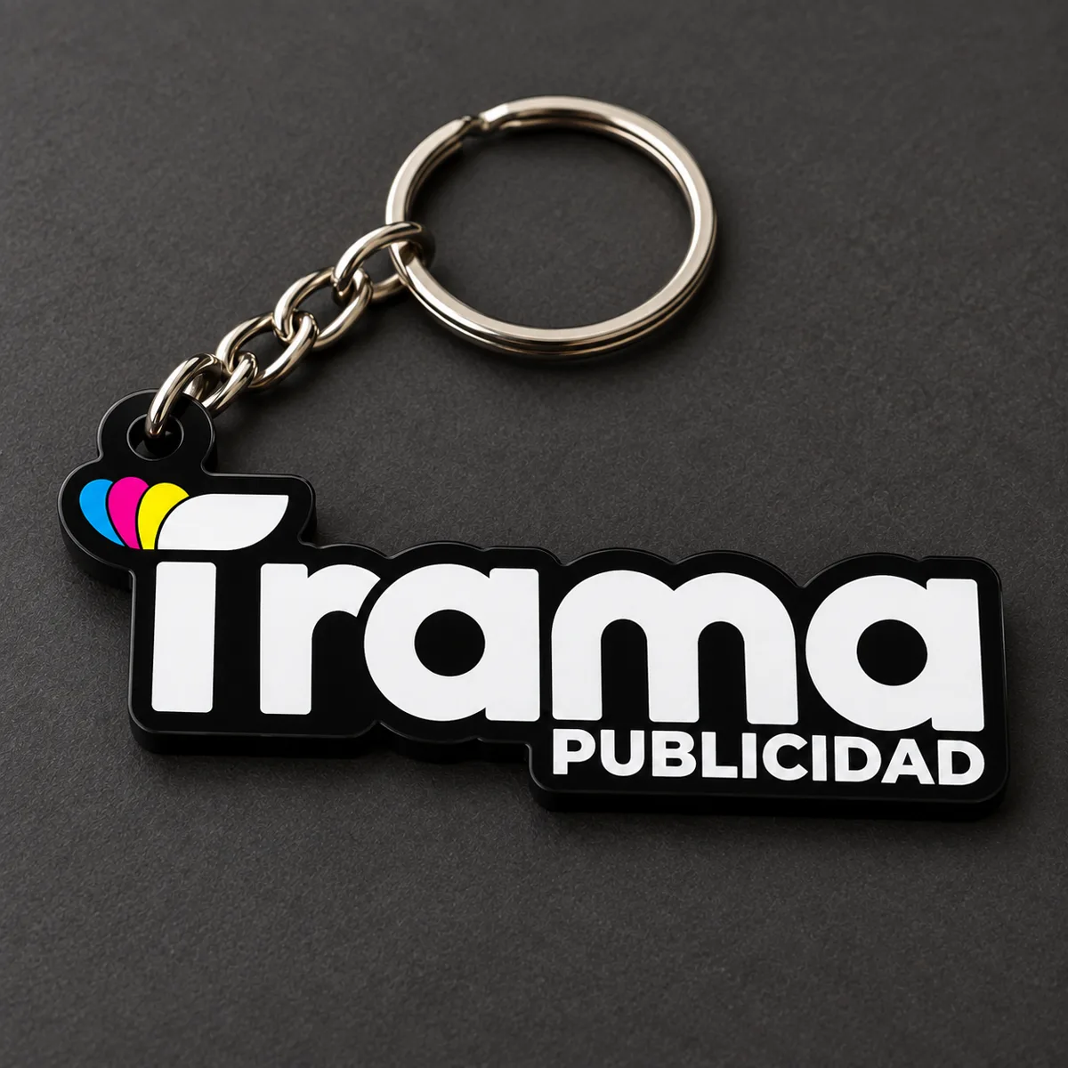 Llavero personalizado de goma con el logo de Trama Publicidad troquelado, a todo color, con argolla y cadena metálica